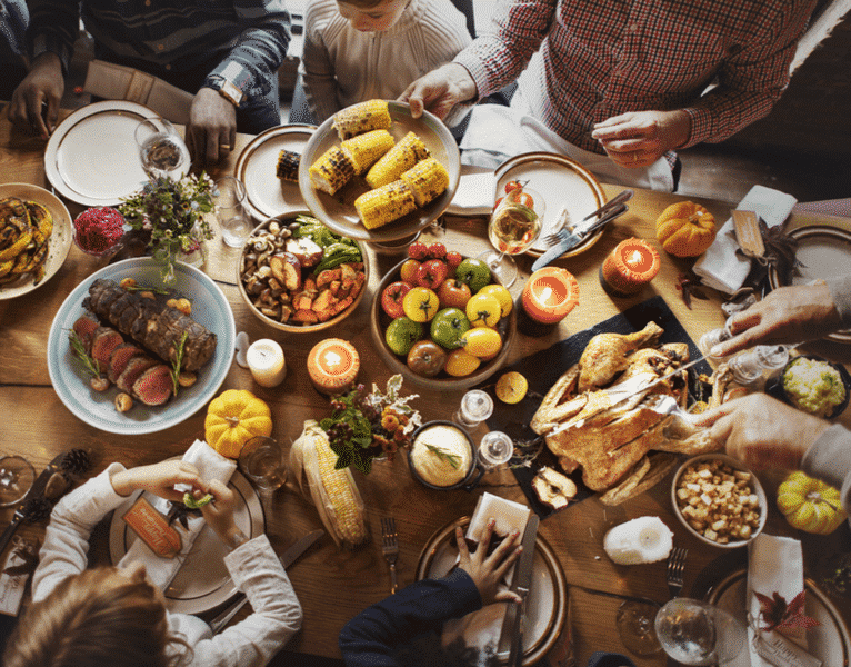 Family gathering around Thanksgiving dinner table
